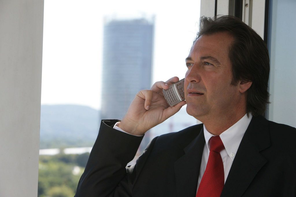 Businessman standing at the window and talking on the phone